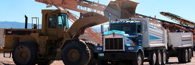 a bulldozer and a truck are parked next to each other in the desert