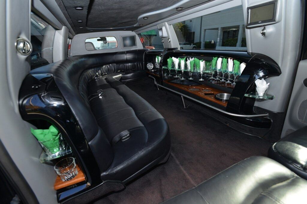 Interior of a black limousine with leather seating and a built-in bar.