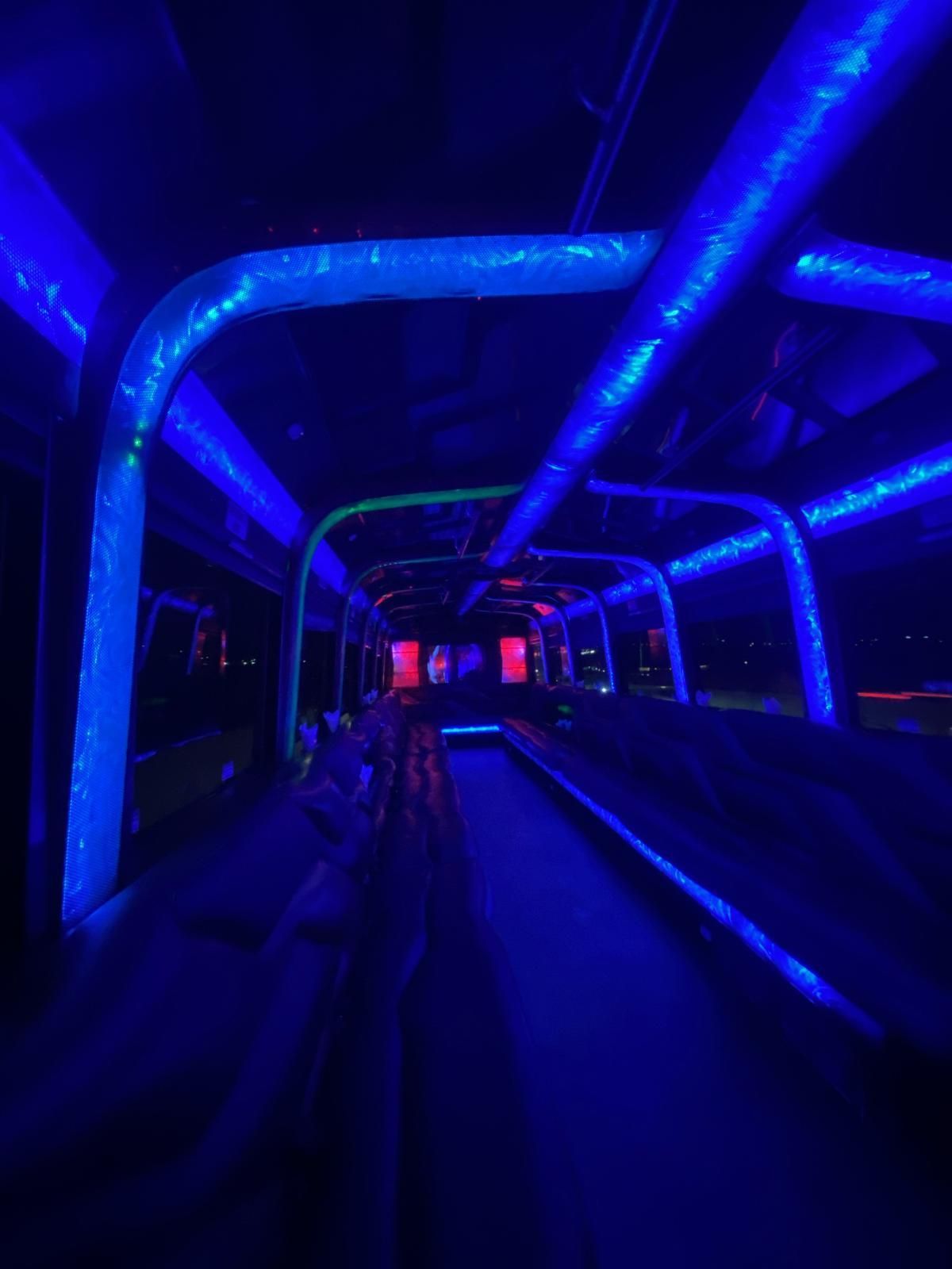 Dark, blue-lit tunnel with a conveyor belt-like structure; red lights glow in the distance.