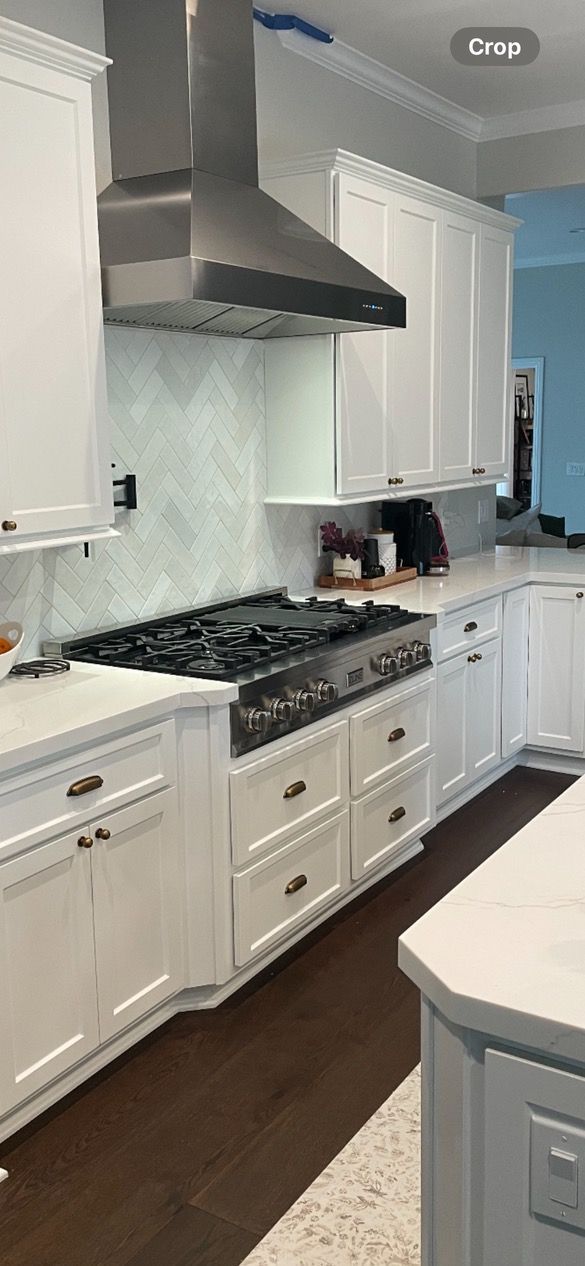 A kitchen with white cabinets and a stovetop oven.