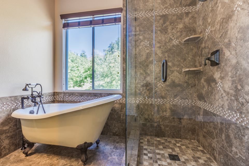 A bathroom with a claw foot tub and a walk in shower.