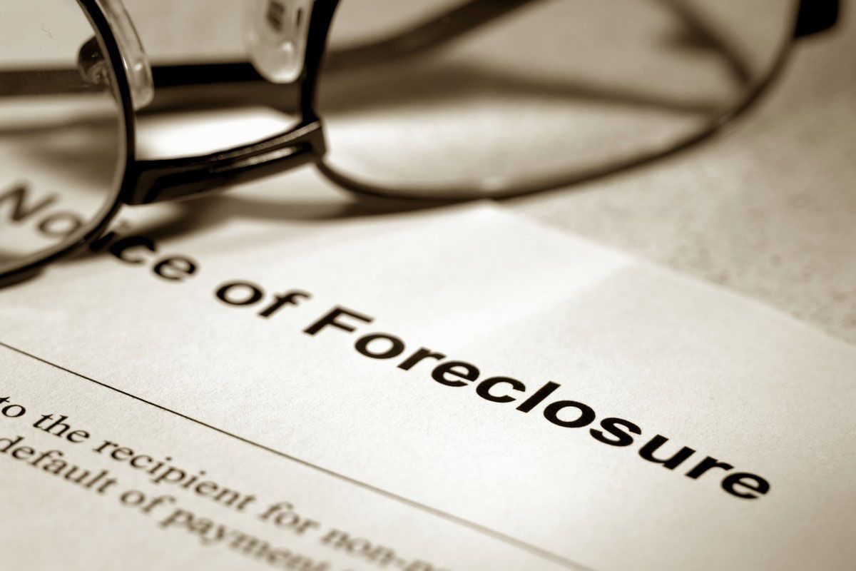 Close-up of a notice of foreclosure, with eyeglasses resting on the document.