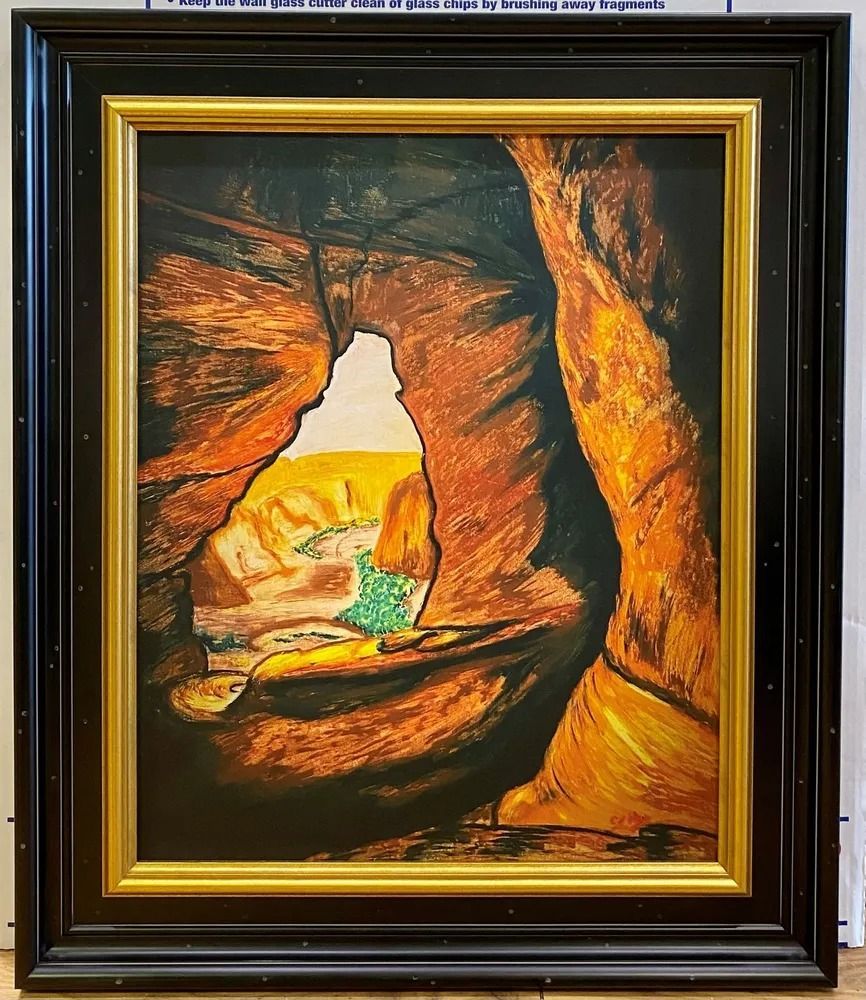 Painting of a desert canyon archway with orange and brown rock formations framing a green and yellow landscape.