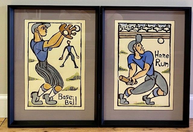Two framed art prints of stylized baseball scenes. One depicts a player catching a ball.