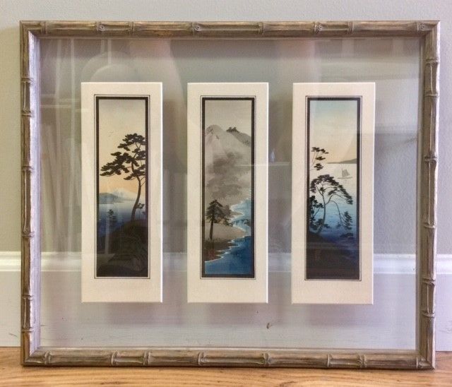 A framed triptych of East Asian landscape paintings, each in a rectangular frame.