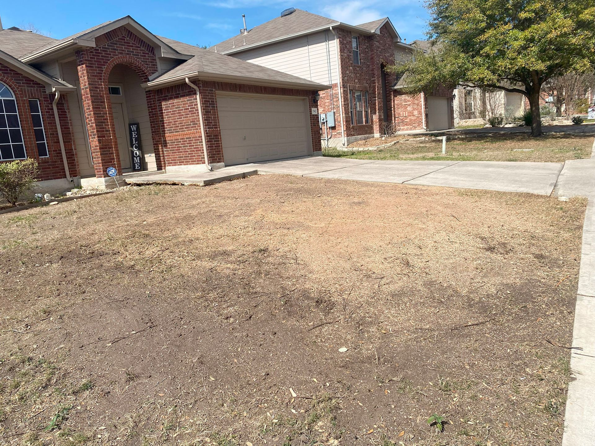 A house with a lot of dry grass in front of it.