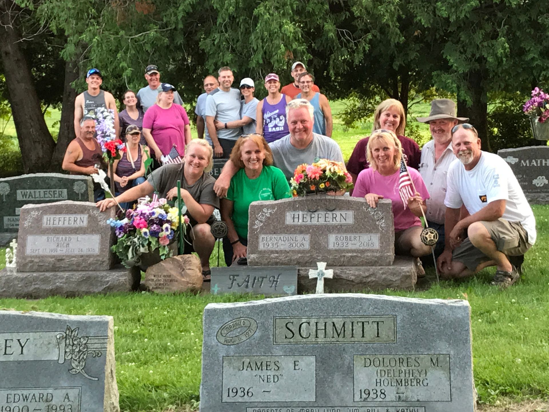 A group of people are posing for a picture in front of graves in a cemetery