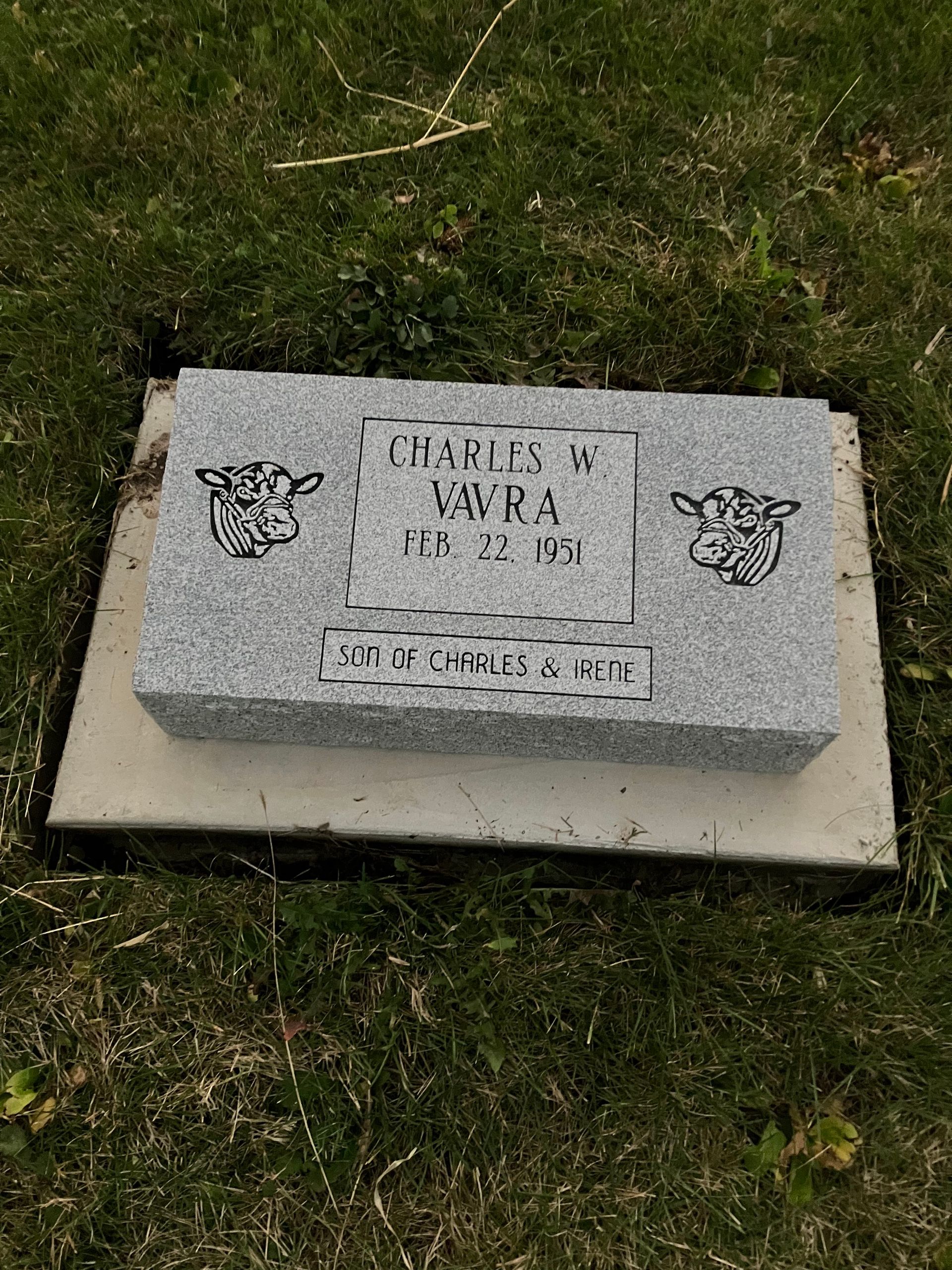 A gravestone is sitting in the grass in a cemetery