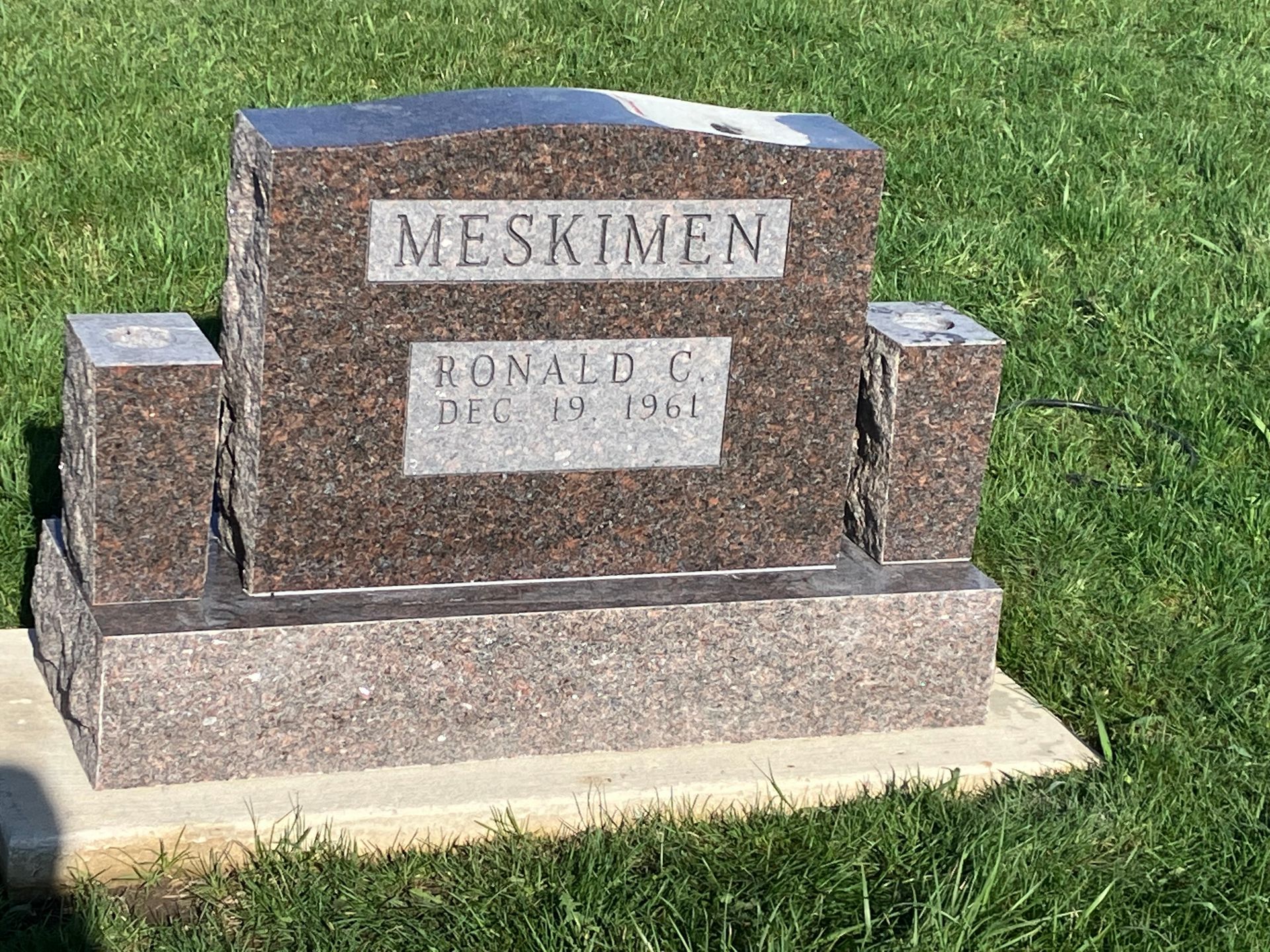 A gravestone in a cemetery with the name Meskimen on it