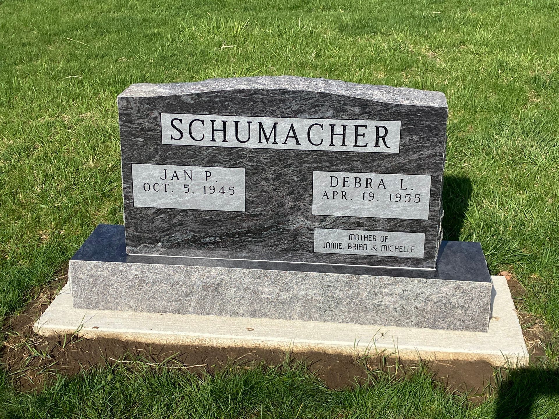 A gravestone in a cemetery with the name Schumacher on it