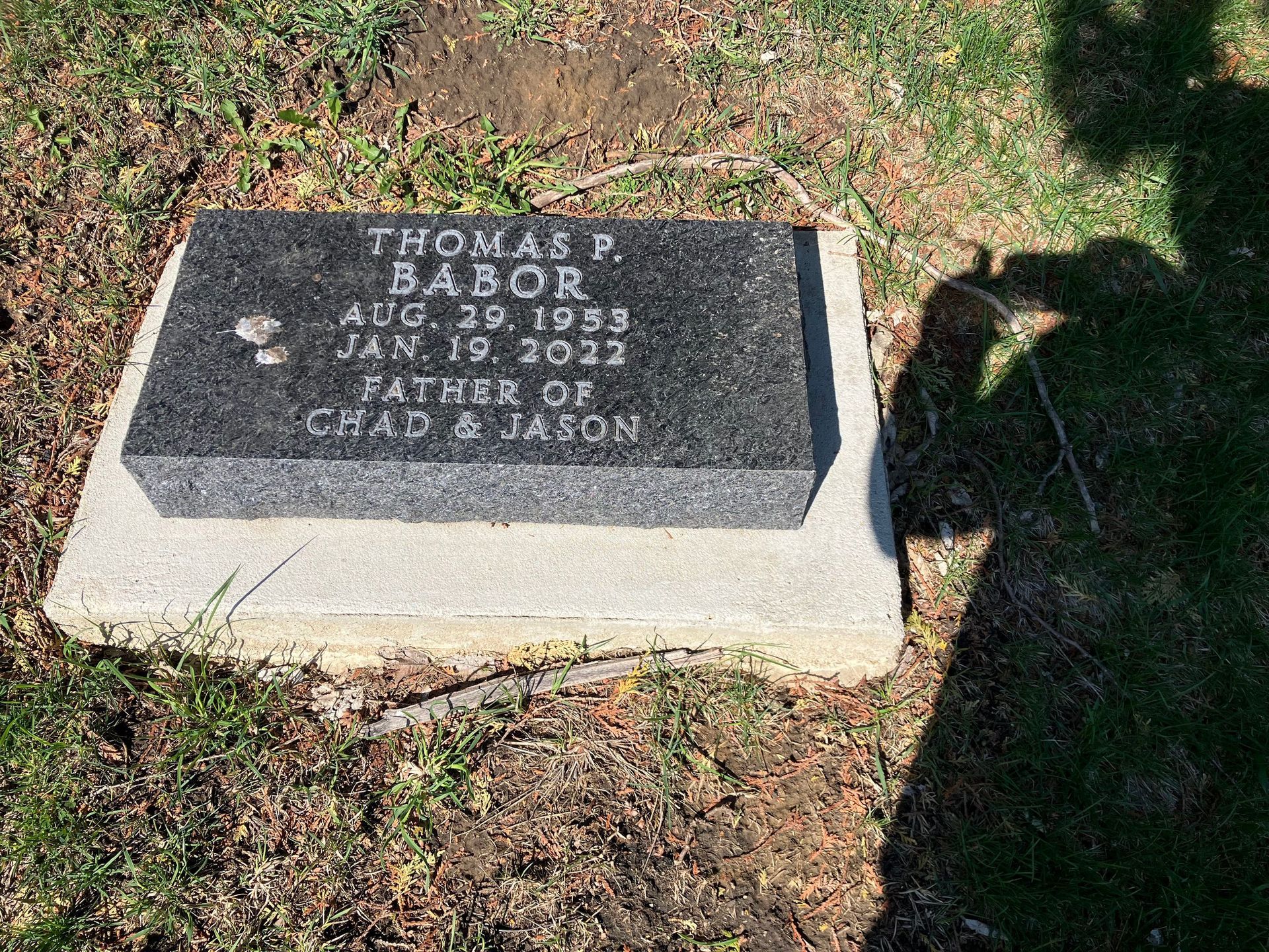 A gravestone in a cemetery with the name Thomas Babor written on it