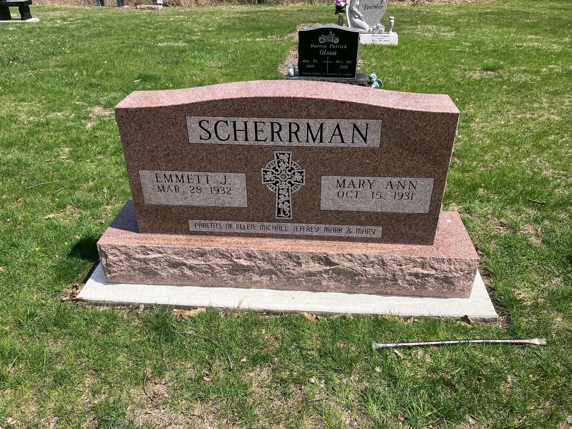 A grave in a cemetery with a cross on it
