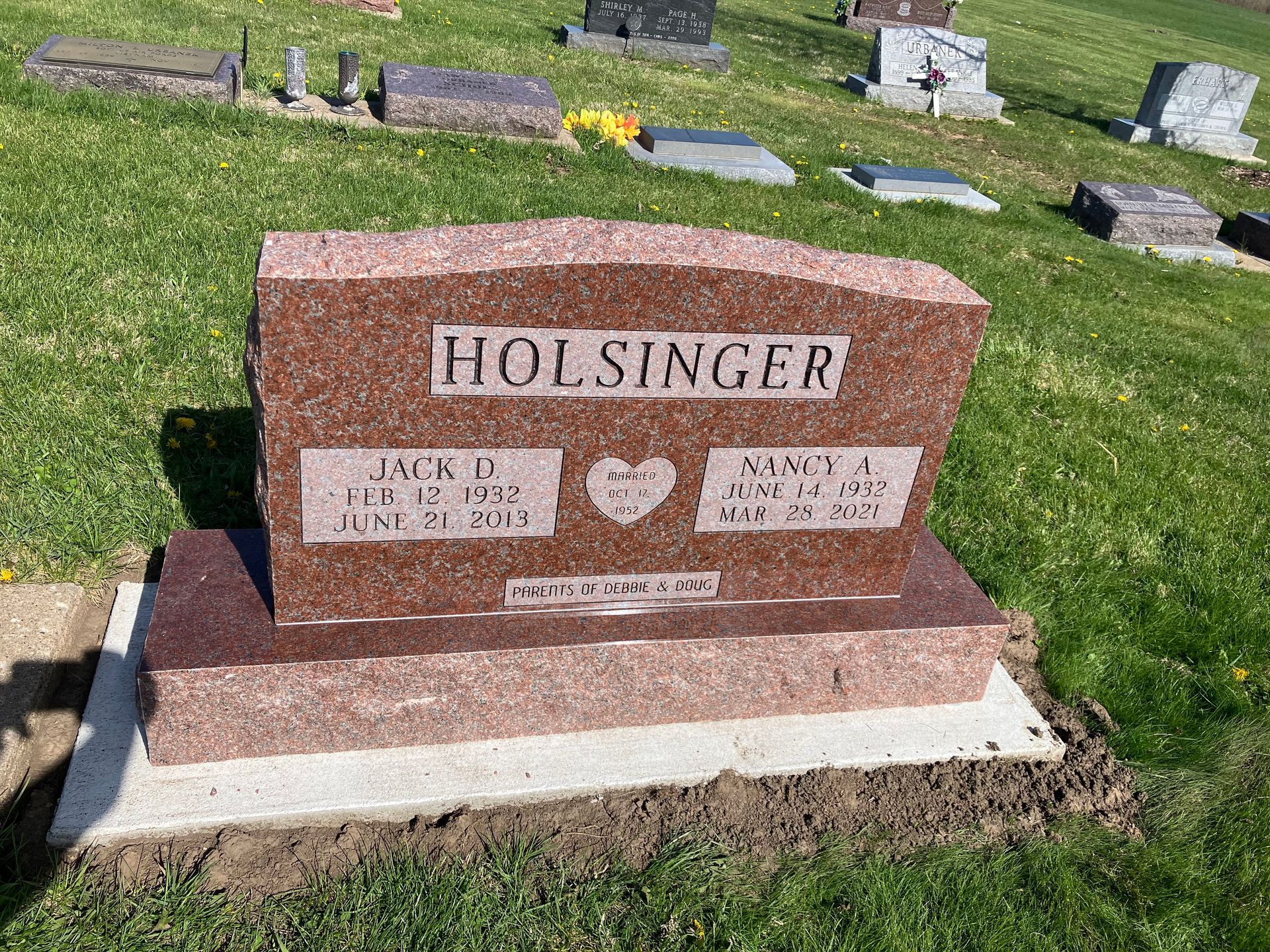A gravestone in a cemetery with a heart on it