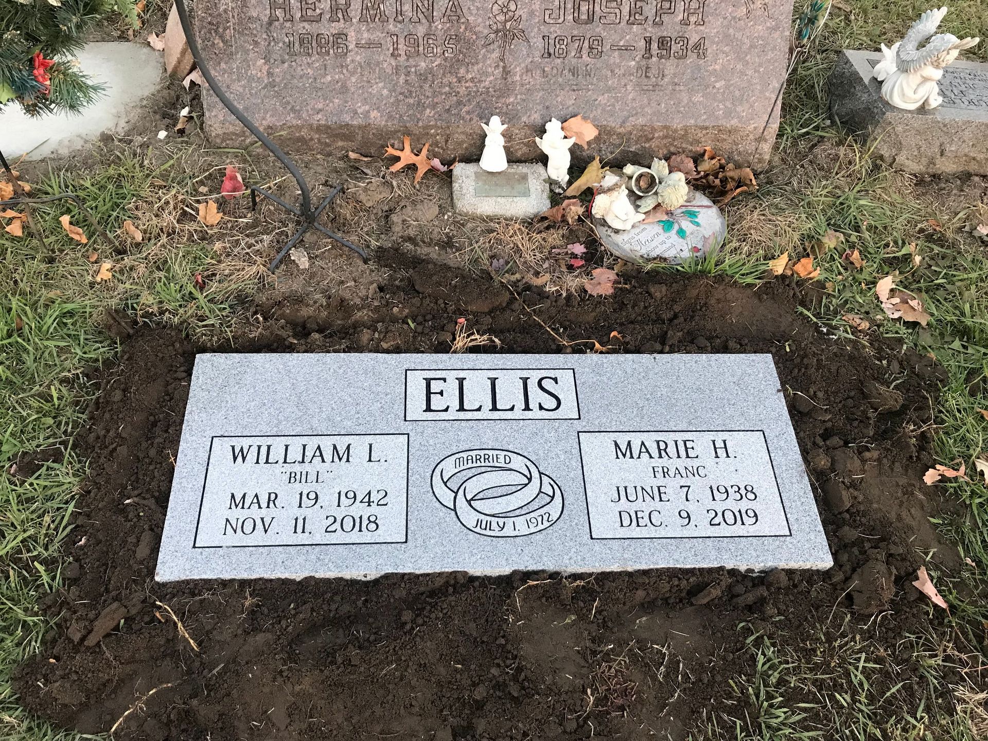 A couple of graves in a cemetery with flowers on them