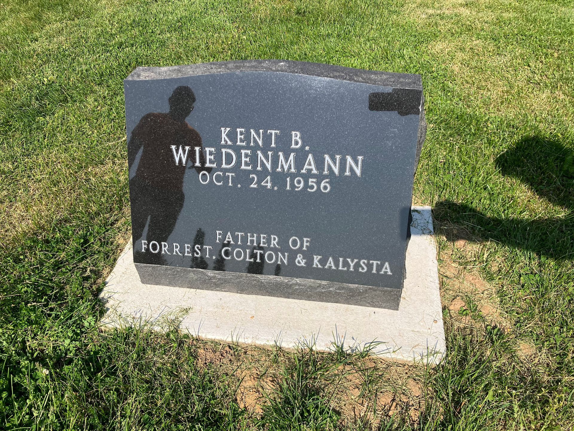 A gravestone in a cemetery for Kent B. Wiedenmann