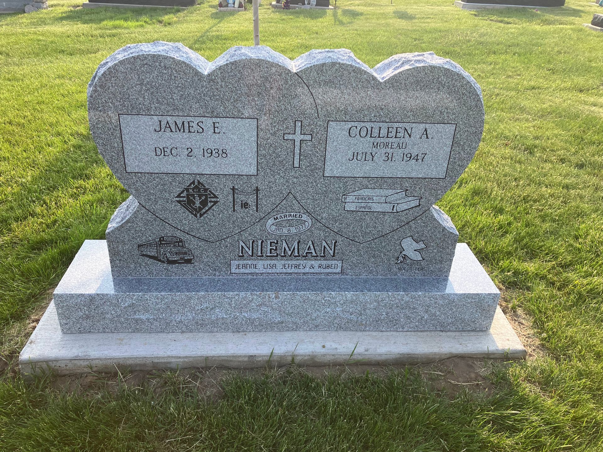 A gravestone in the shape of a heart in a cemetery