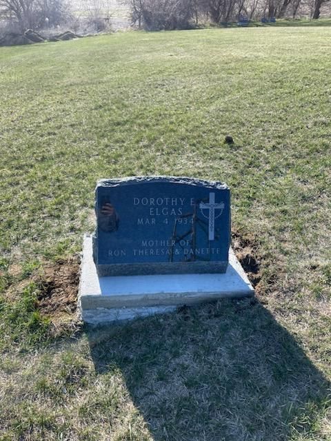 A gravestone in a grassy field with the name Dorothy on it