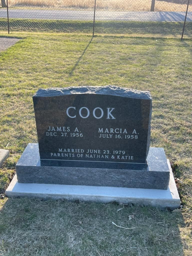A gravestone for James and Marcia Cook in a cemetery