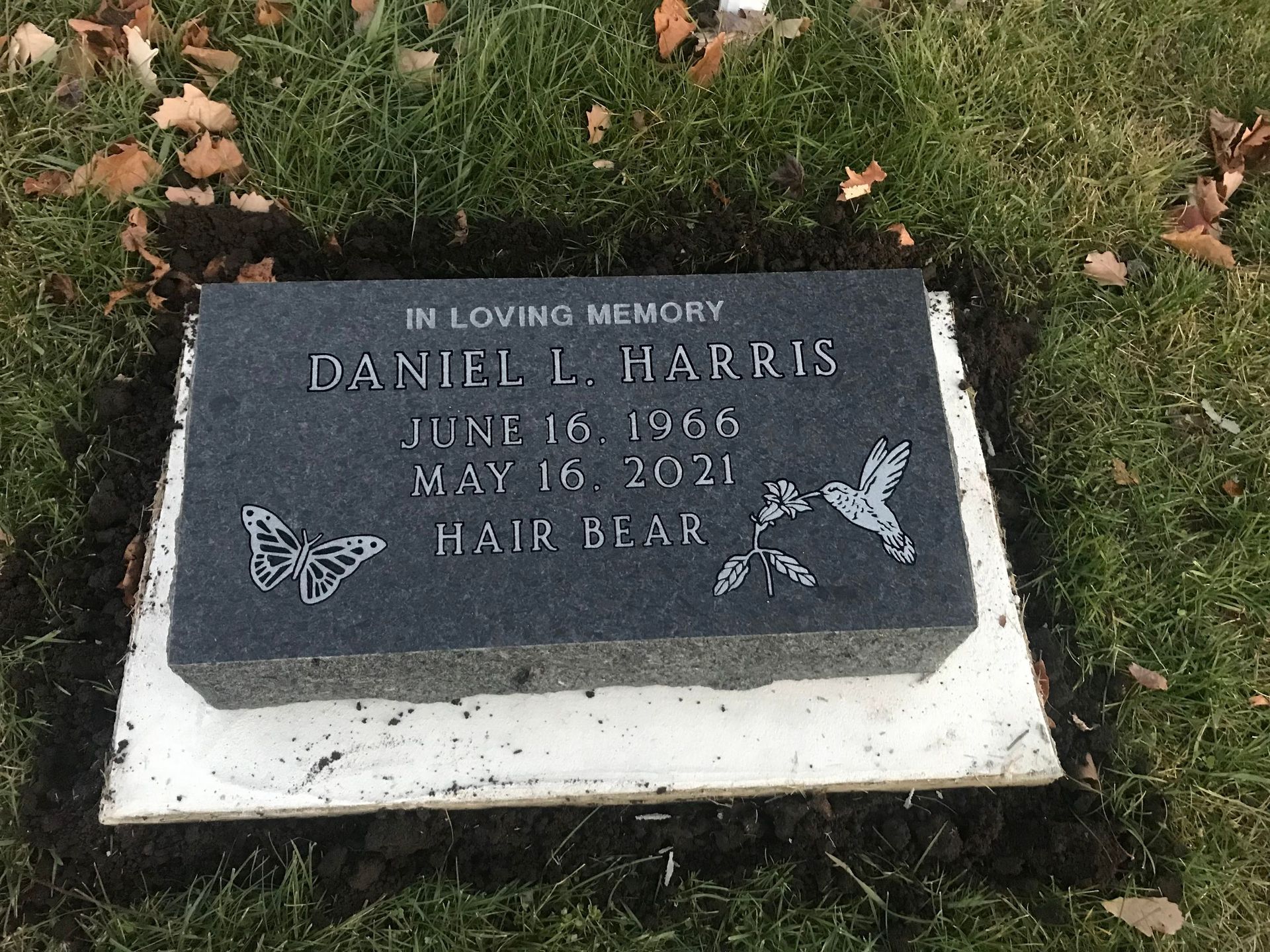 A gravestone in a cemetery with a butterfly on it