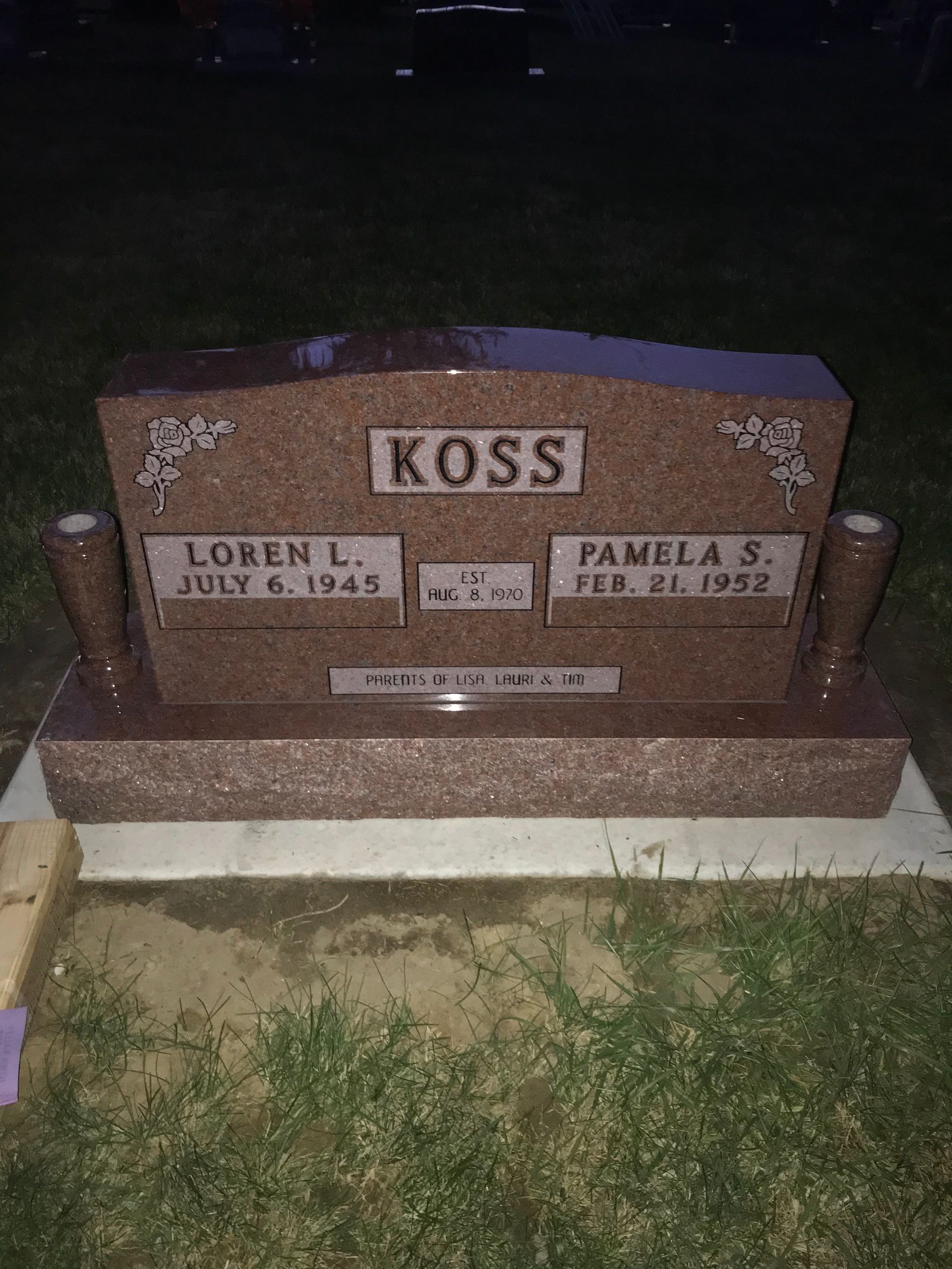 A gravestone in a cemetery with the name Koss on it