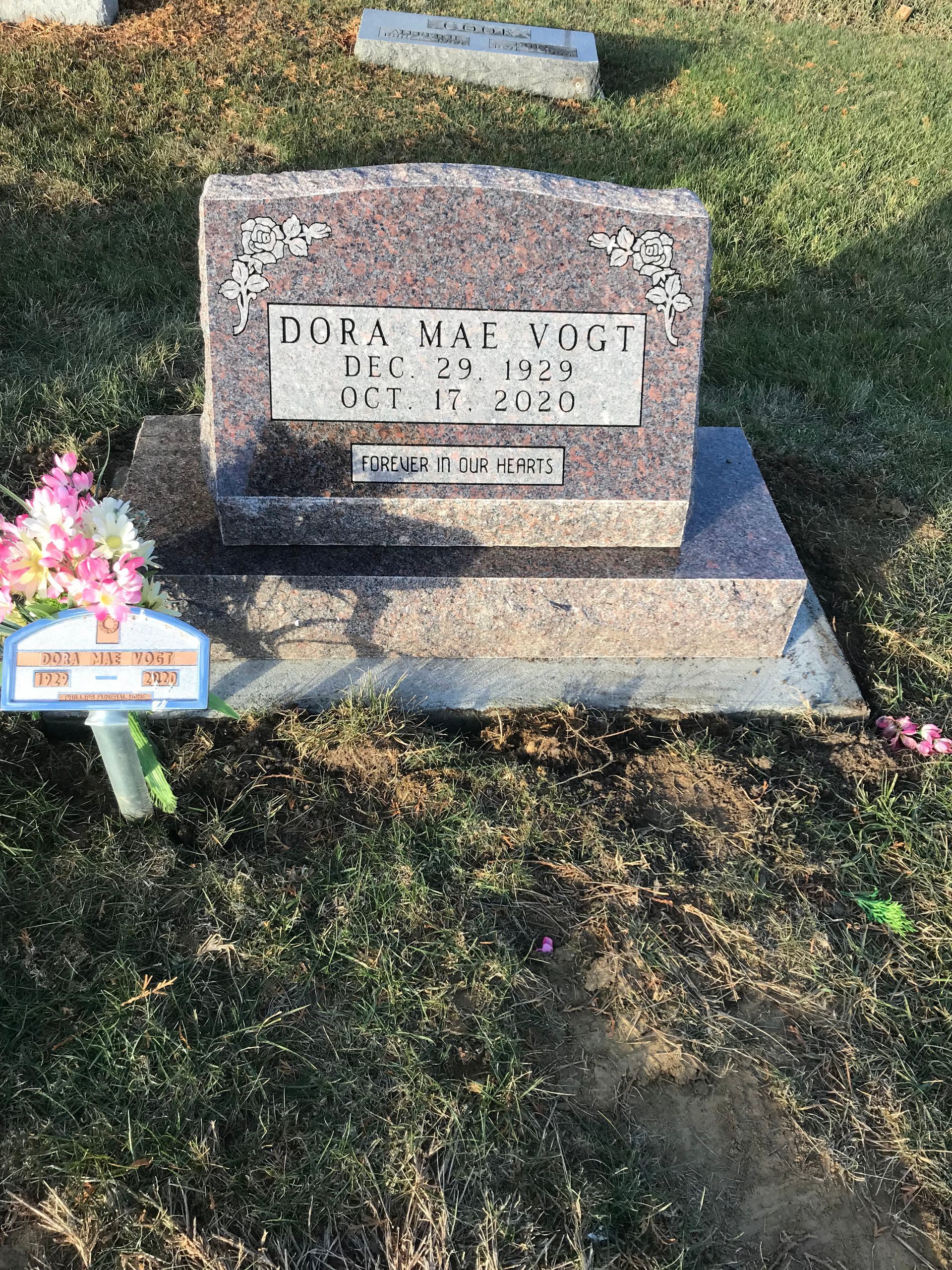 A gravestone in a cemetery with flowers on it