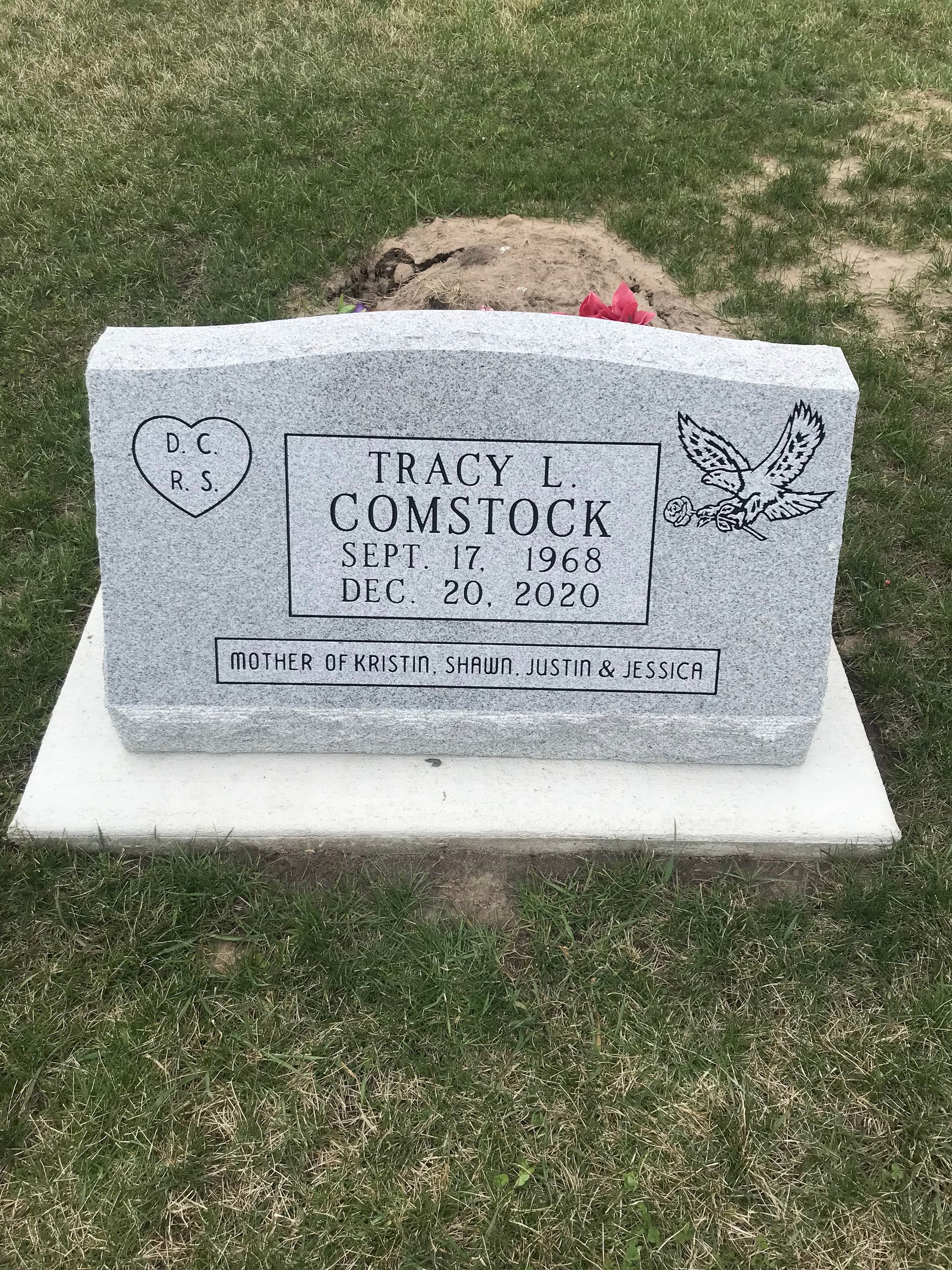 A gravestone for Tracy L Comstock is in a cemetery