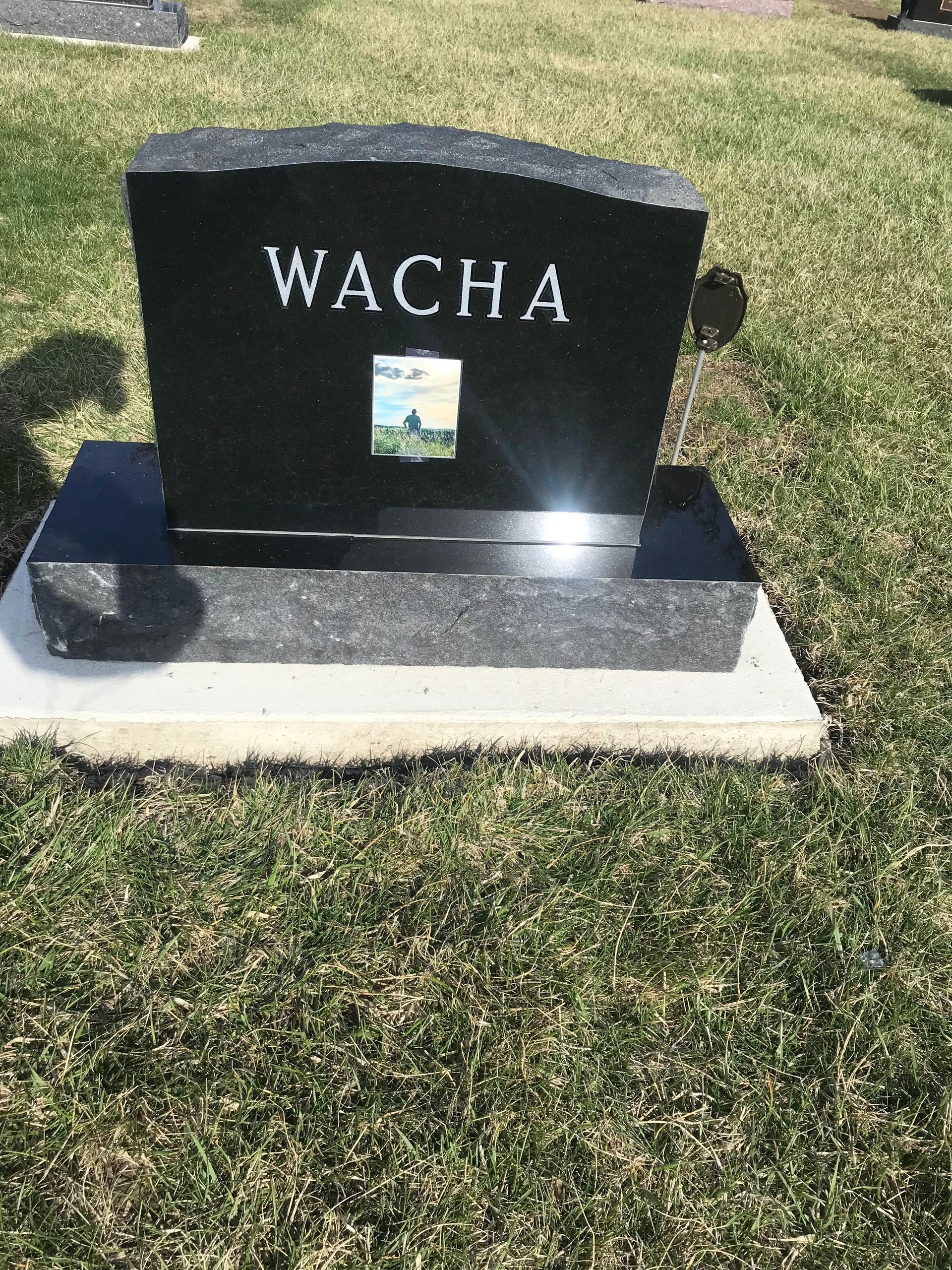 A black gravestone with the name Wacha on it