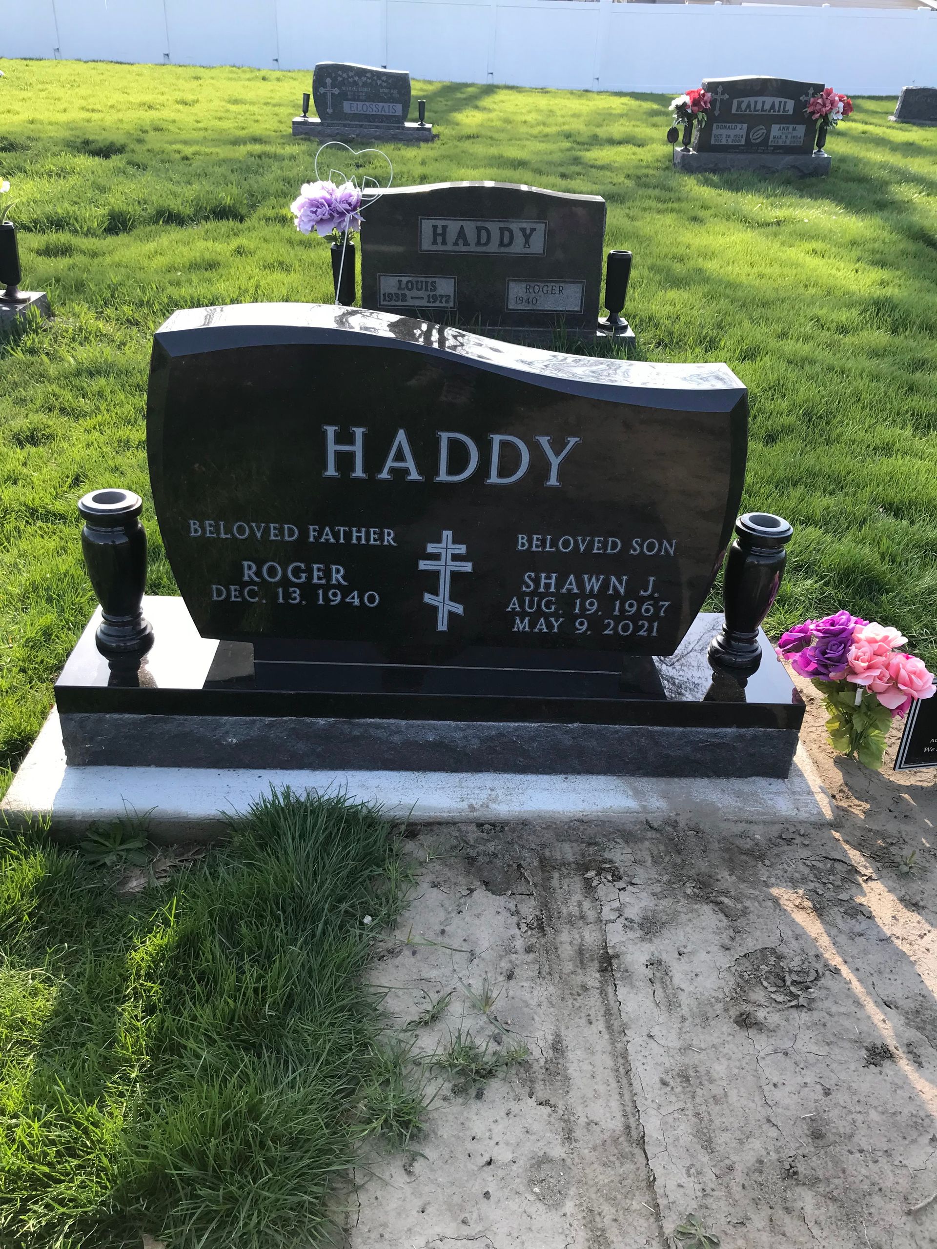 A black gravestone with the name Haddy on it is in a cemetery