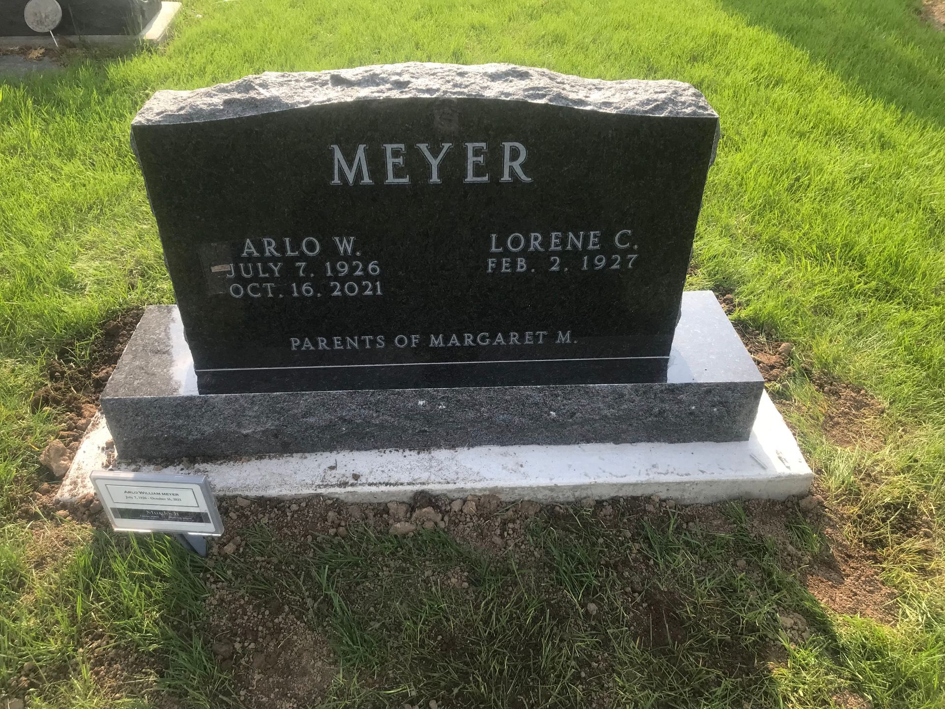 A black gravestone in a cemetery with the name Meyer on it