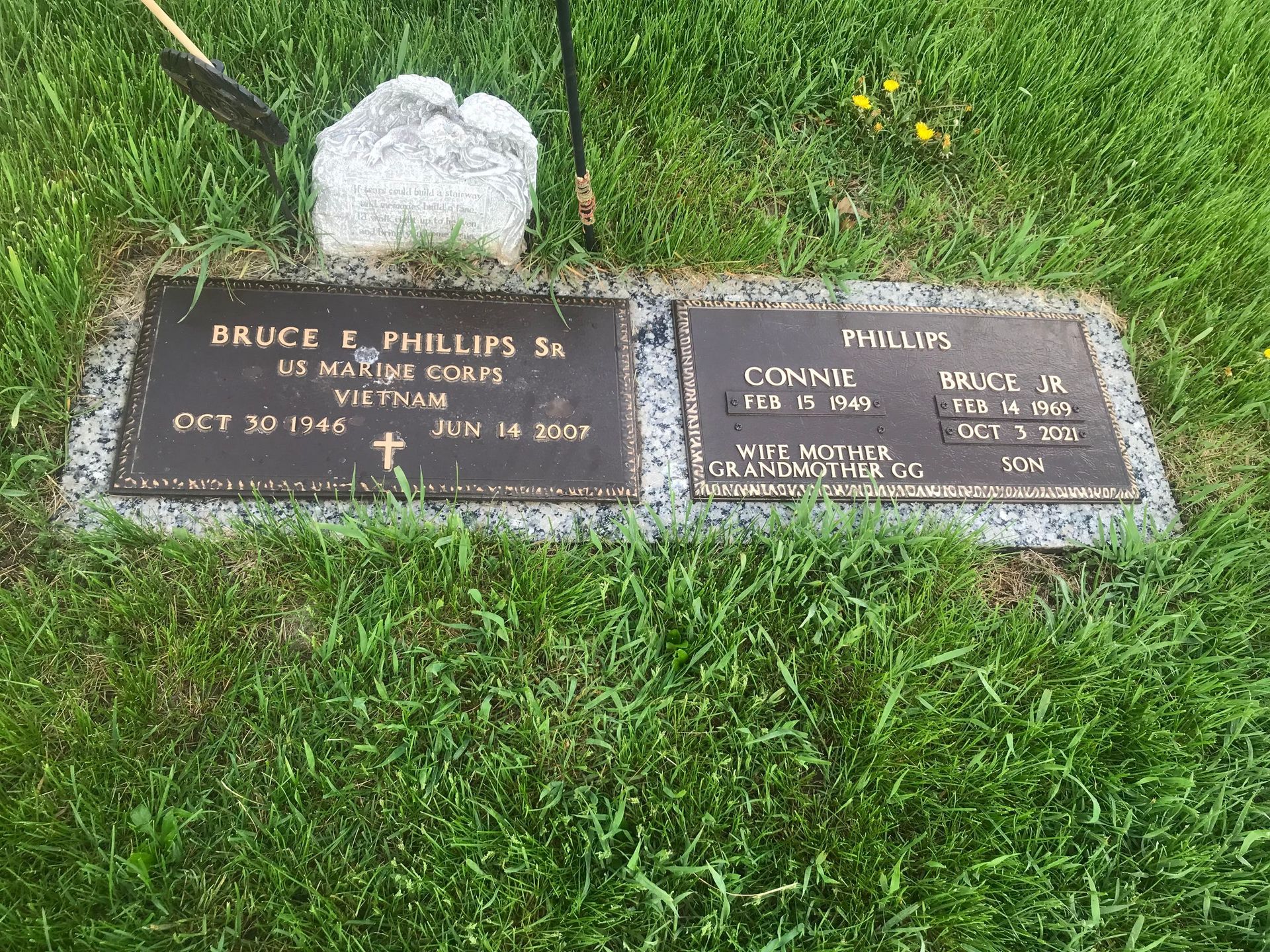 A couple of grave markers sitting on top of a lush green field