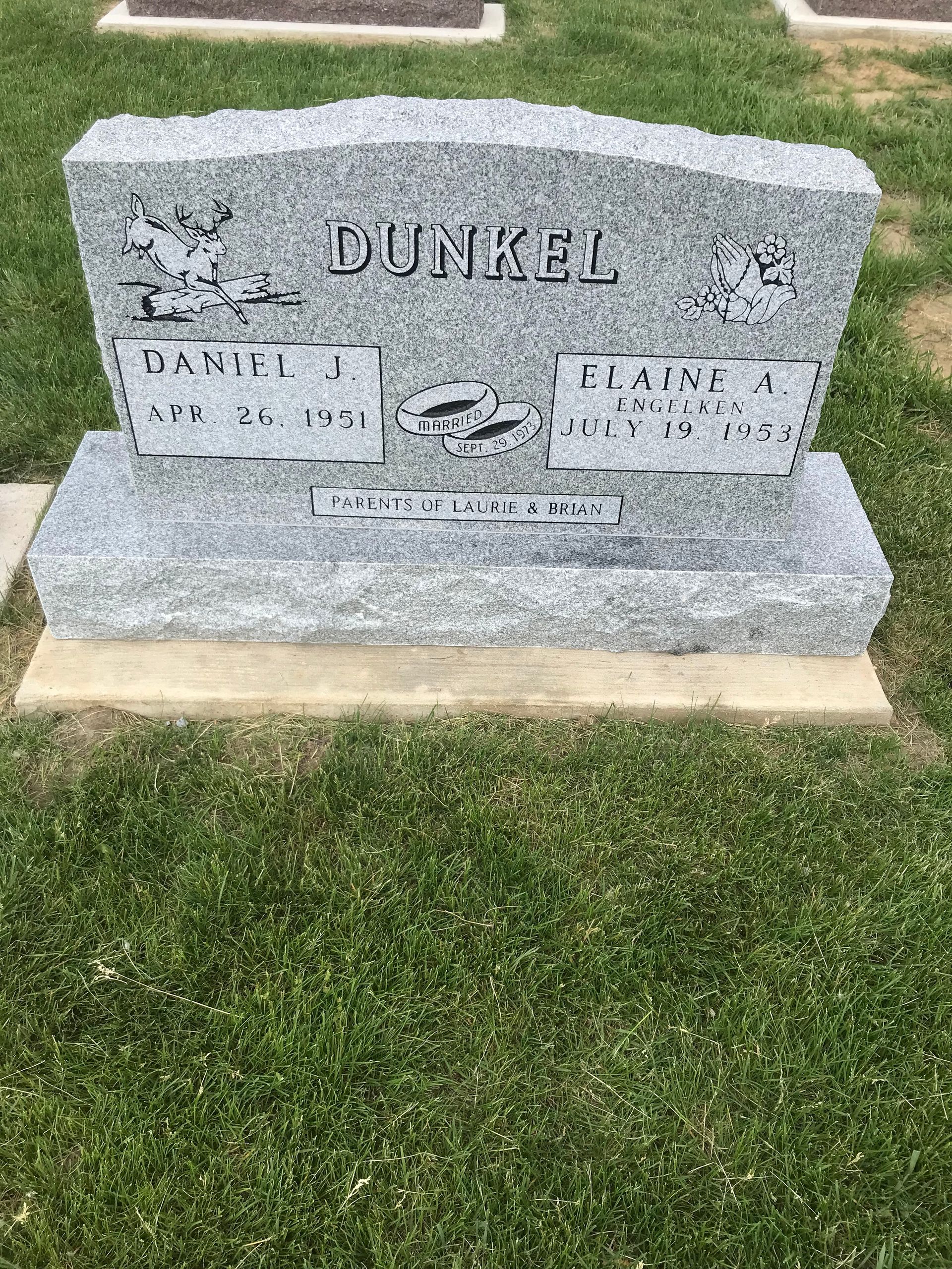 A gravestone in a cemetery with a lot of grass around it.