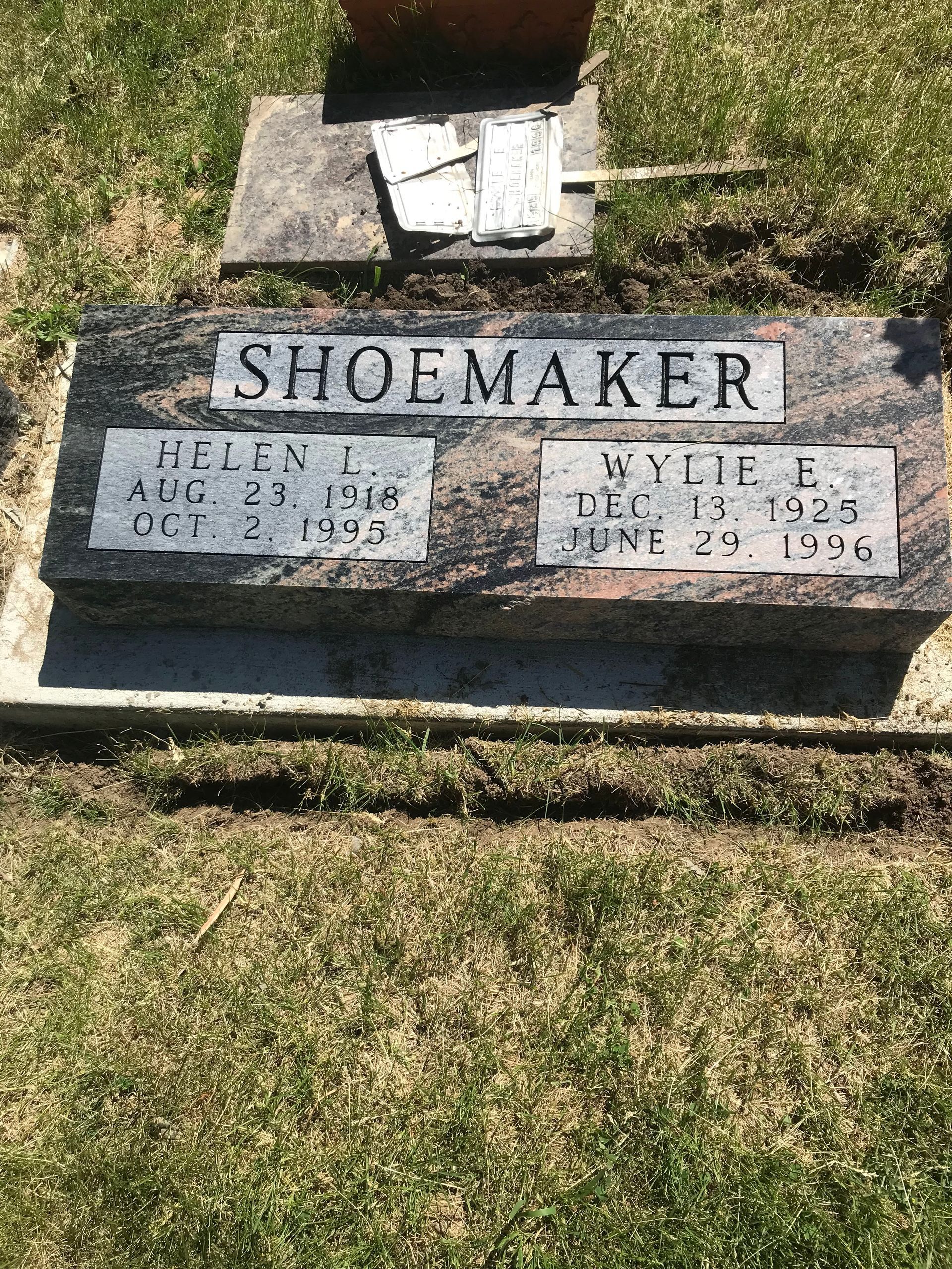 A couple of graves in a cemetery with the name Shoemaker on them.