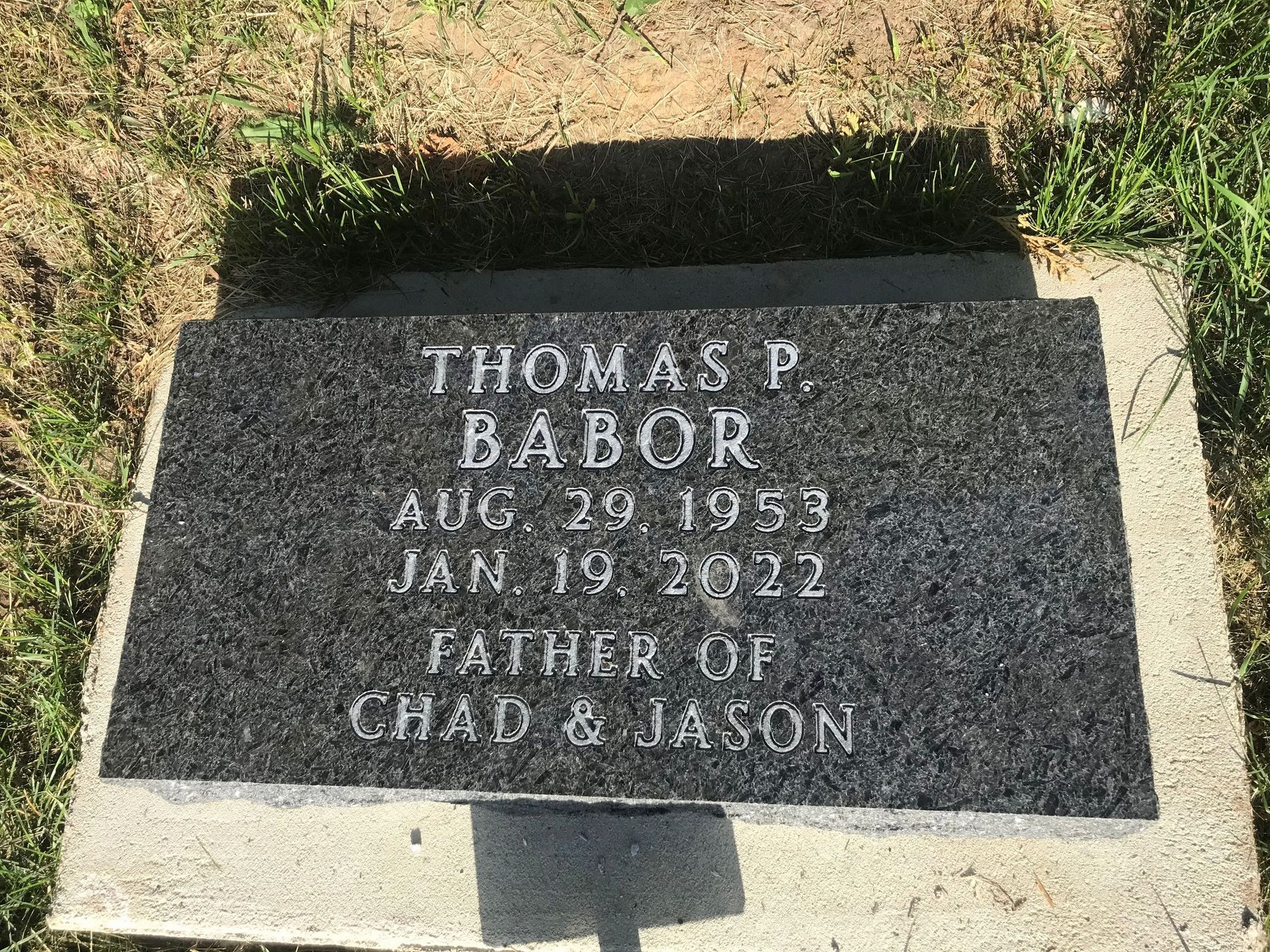 A gravestone in a cemetery with the name Thomas on it.