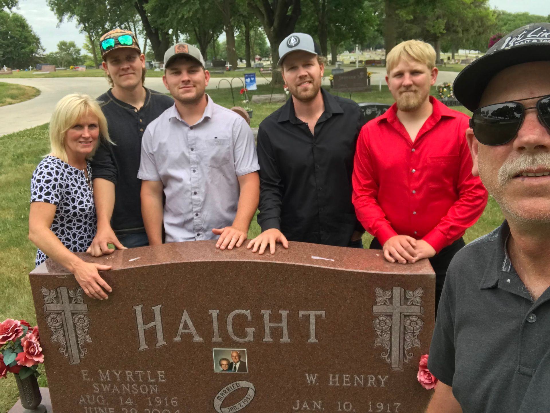 A group of people standing in front of a gravestone that says Haight