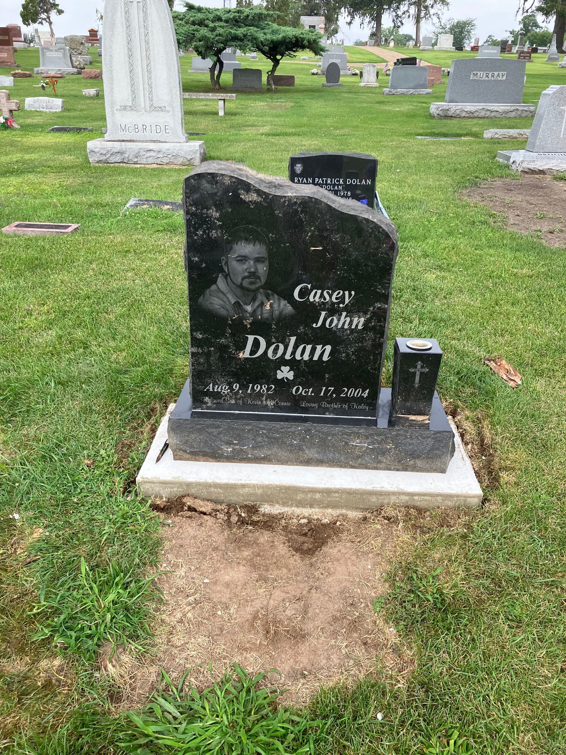 A gravestone in a cemetery with a picture of a man on it.