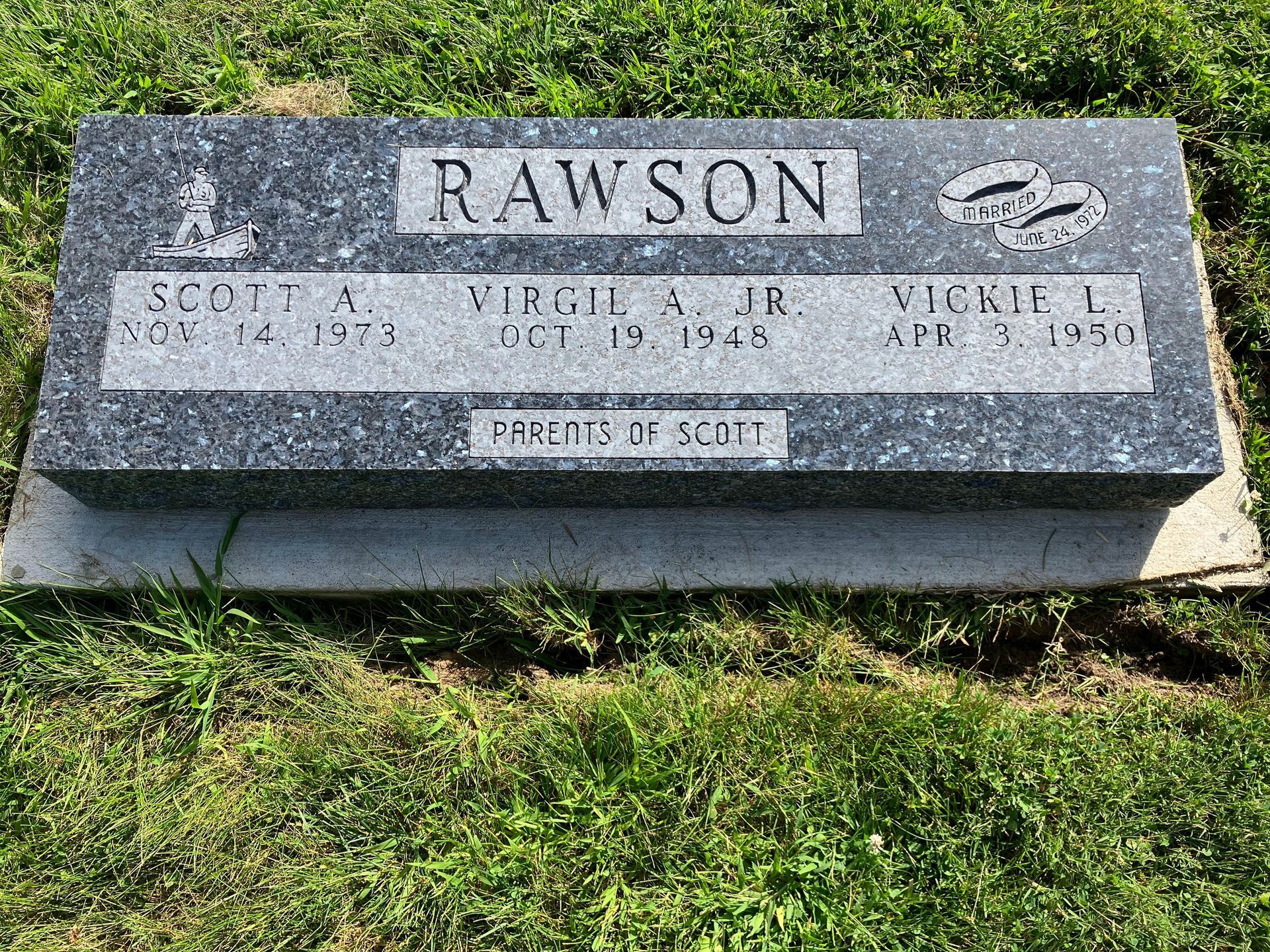 A gravestone for rawson is sitting in the grass in a cemetery.