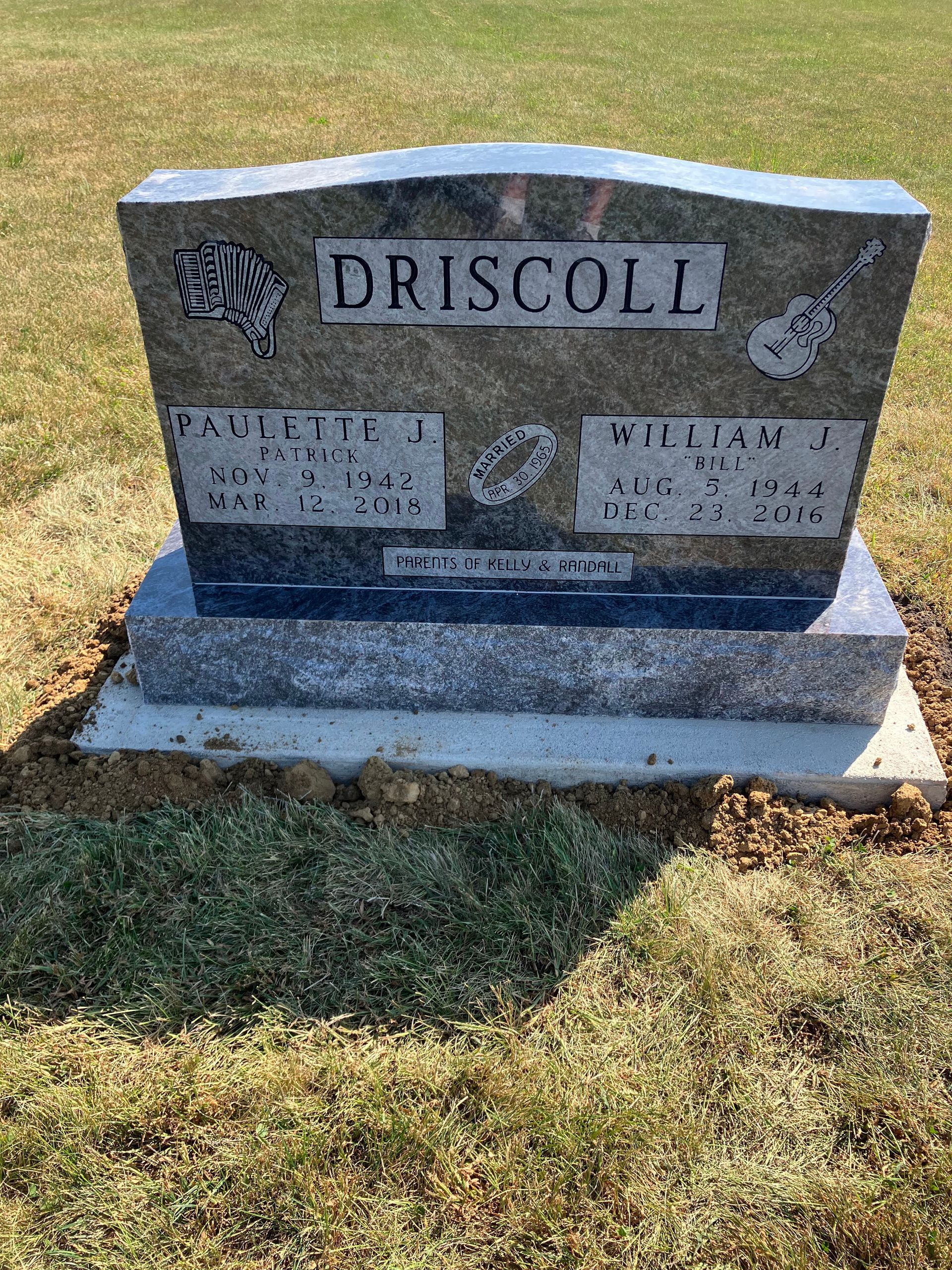 A gravestone in a cemetery with a guitar on it.