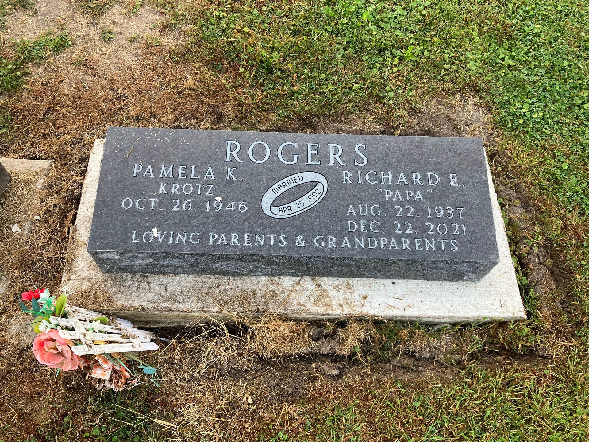 A gravestone in a cemetery with a football on it.