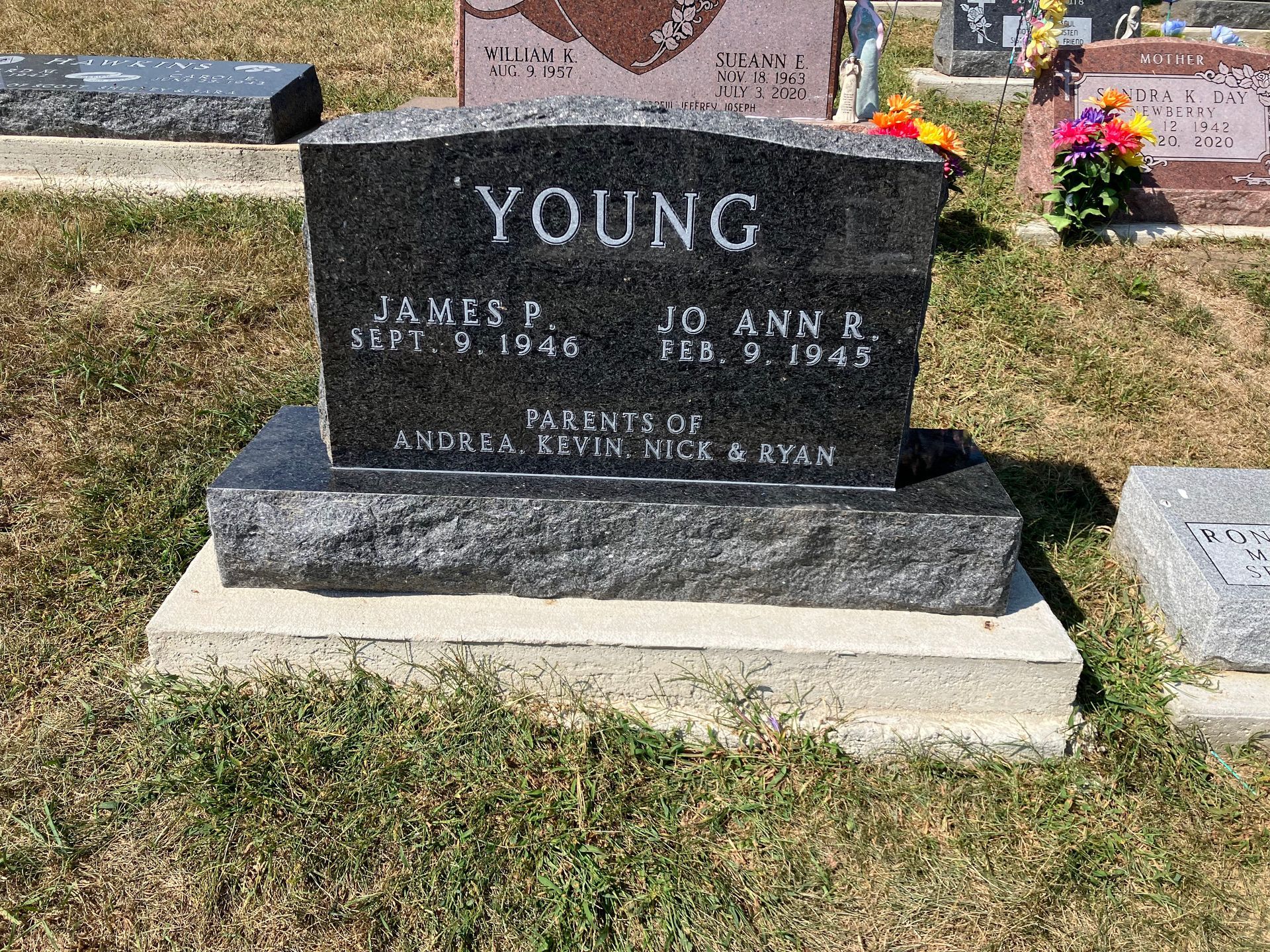 A black gravestone in a cemetery with the name young on it.