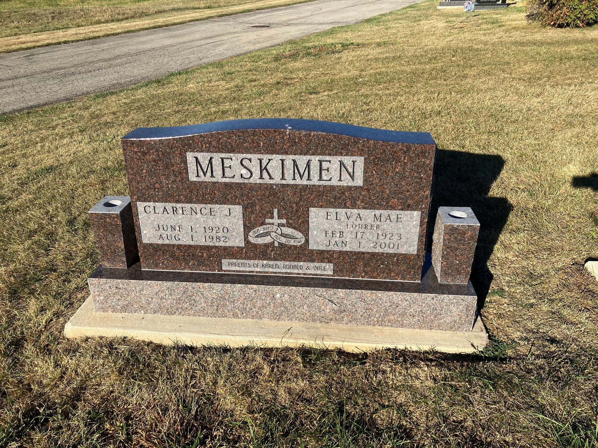 A gravestone is sitting in the middle of a grassy field.