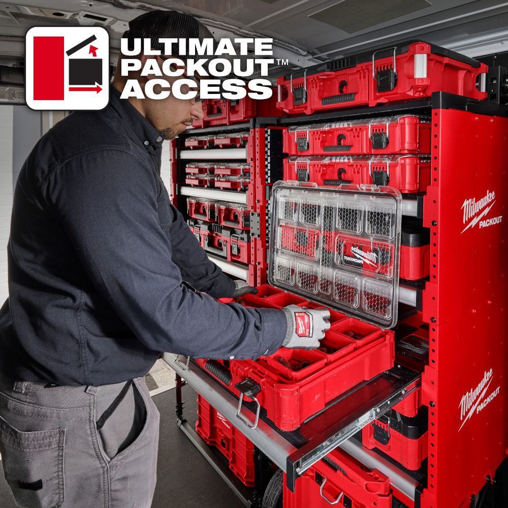 Worker organizing tools in a red Milwaukee Packout tool chest with