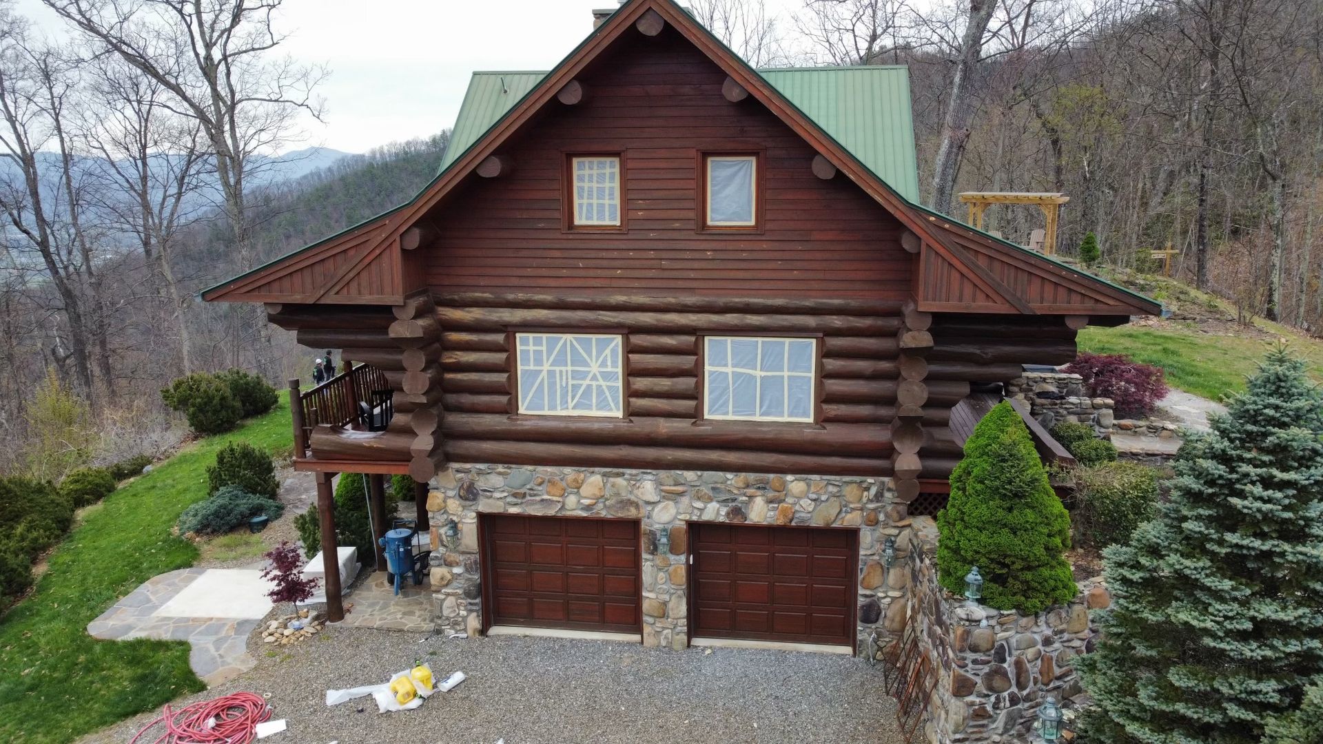 An aerial view of a log cabin with a metal roof