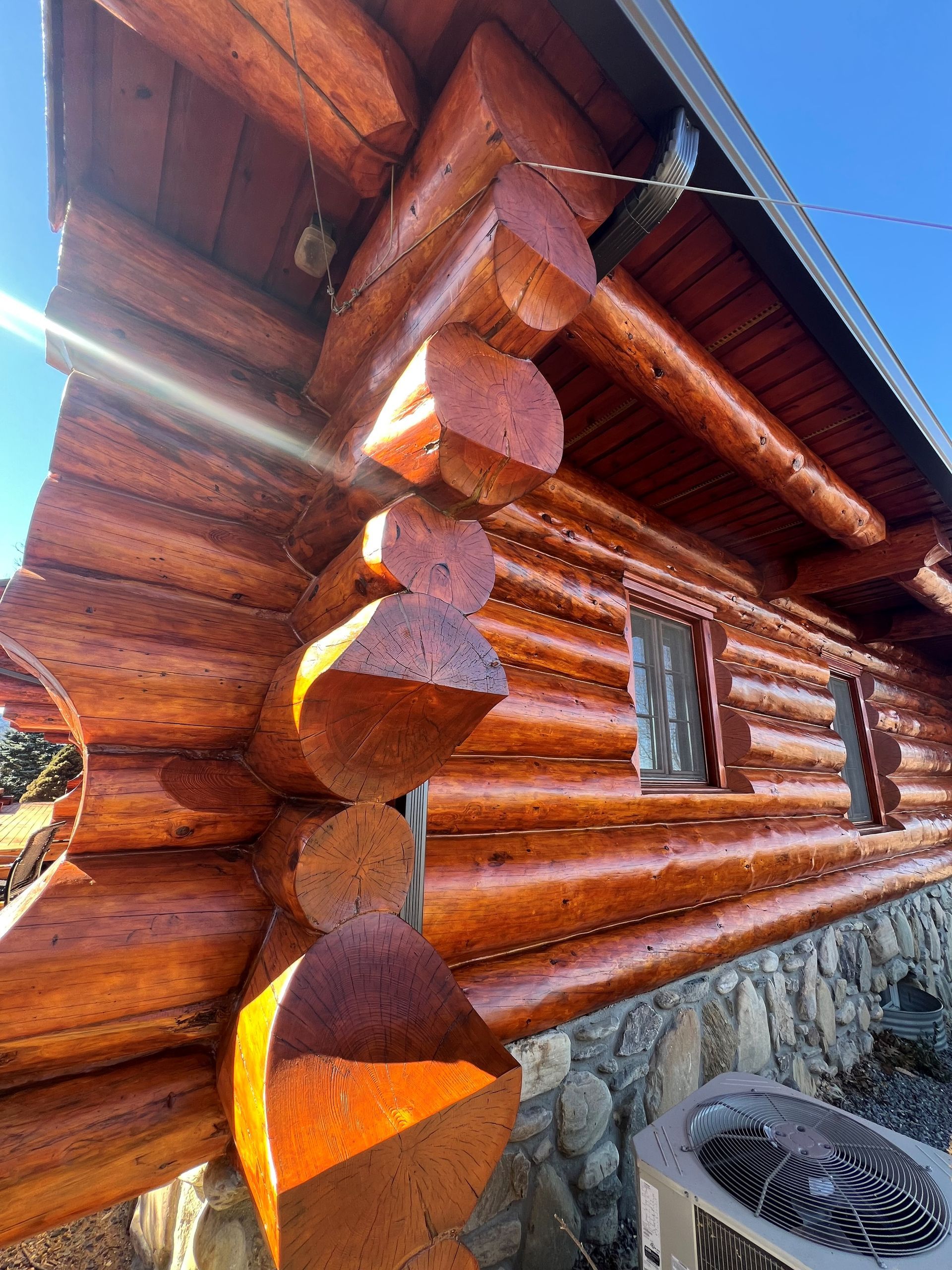 A log cabin with a fan on the side of it.
