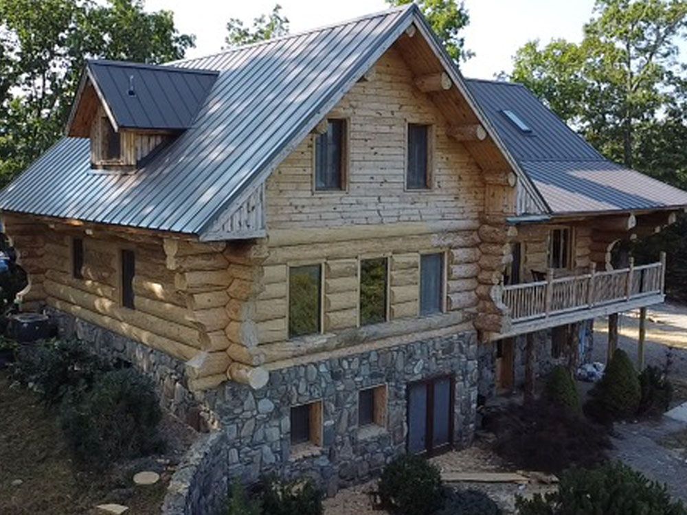 An aerial view of a log cabin with a metal roof