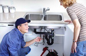 A woman talking to the plumber