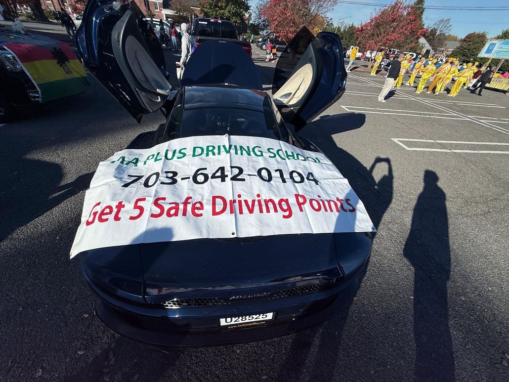 Dark blue car with gullwing doors open, banner reads "AAA Plus Driving School", phone number, "Get 5 Safe Driving Points".