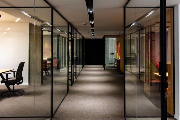 A long hallway with glass walls leading to a conference room.