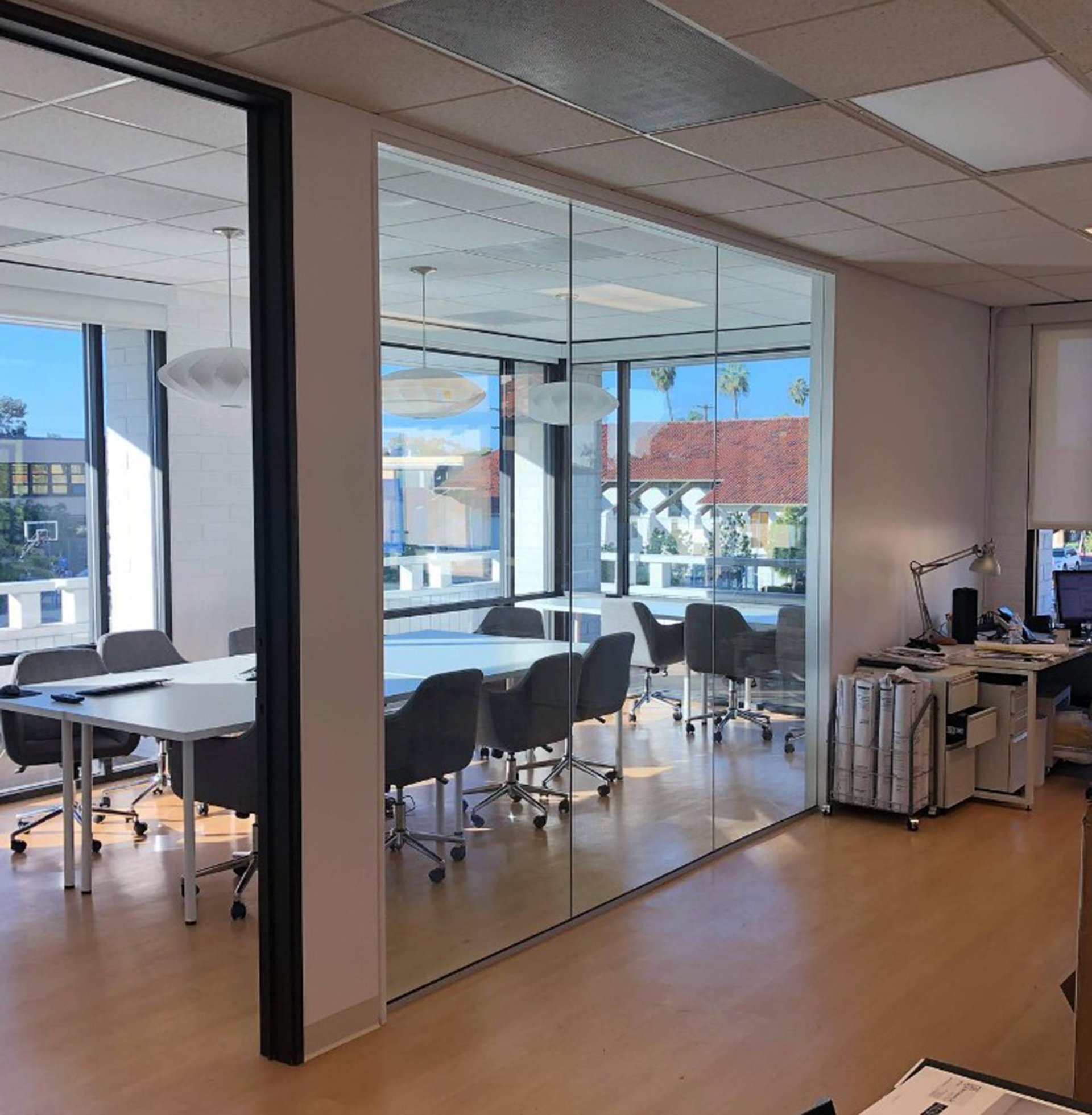 A conference room with tables and chairs and a glass wall