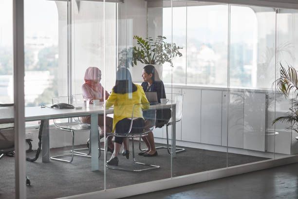 A group of people are sitting at a table in a conference room.