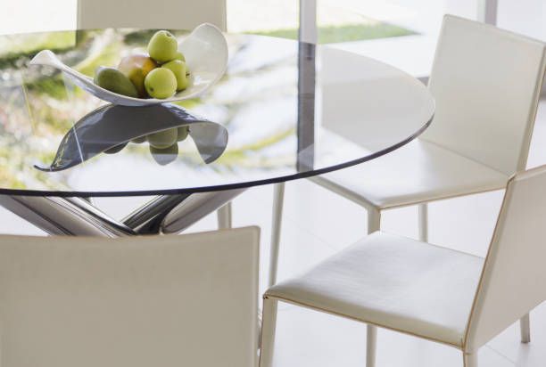 A glass table with a bowl of fruit on it